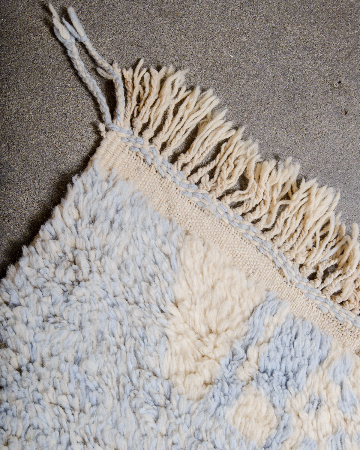 Corner of Azilal rug with natural wool tassels.